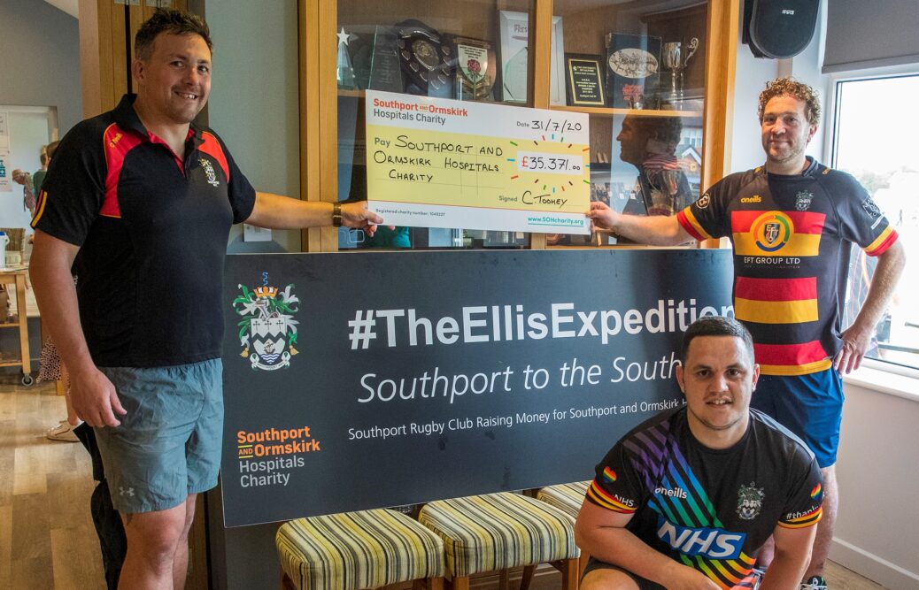 Col Toohey (left), Gareth Lang (back right) and James Cook (front right) from Southport Rugby Football Club with the cheque from The Ellis Expedition