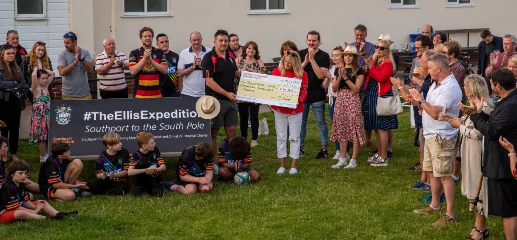 Anne Ellis and Col Toohey and supporters with cheque for over £35,371 raised via The Ellis Exhibition, at Southport Rugby Football Club. Photo by Angus Matheson of Wainwright & Matheson Photography