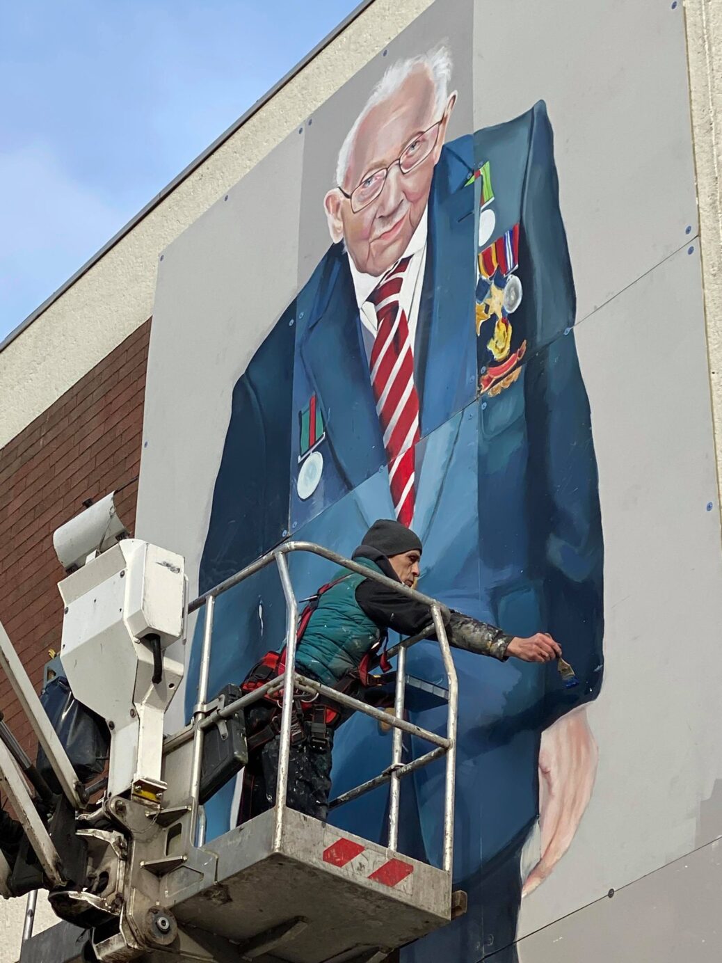 Artist Rob Newbiggin with the huge mural of Captain Sir Tom Moore in Southport