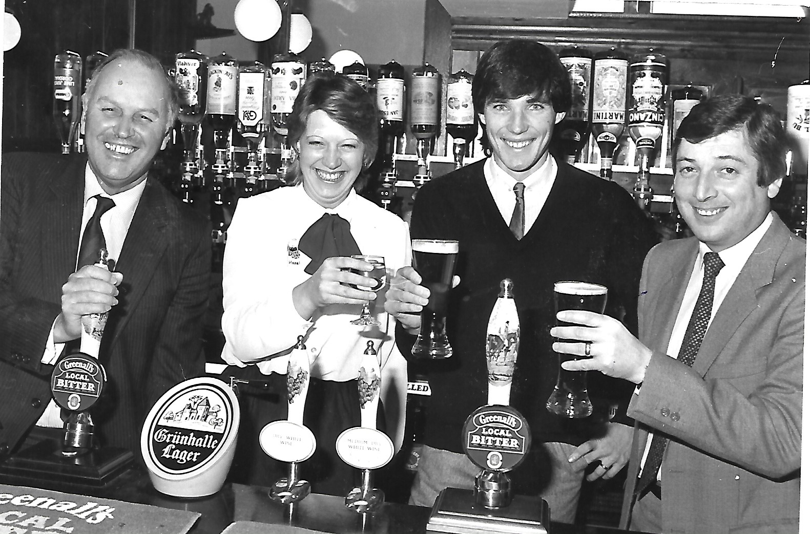 Liverpool FC Captain Alan Hansen says cheers behind the bar of a Southport pub in December 1983