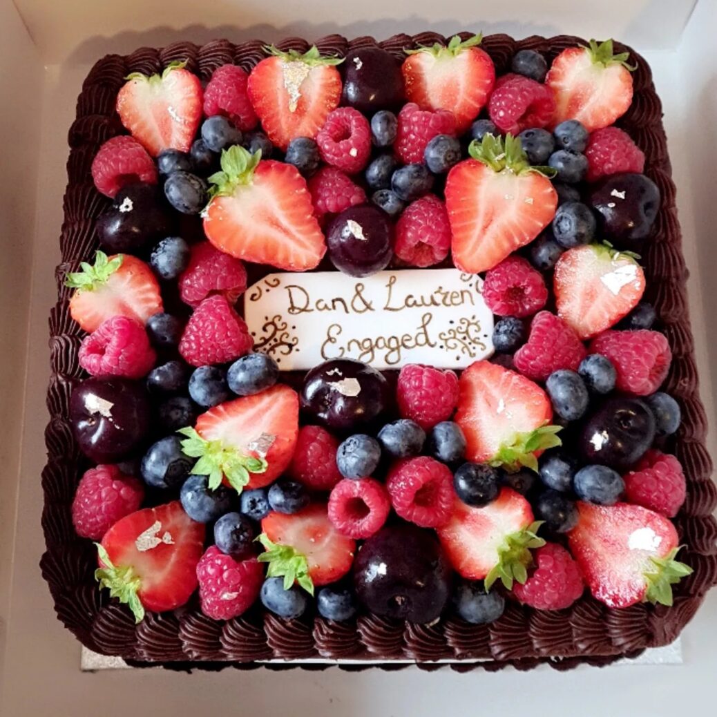 Beautiful Chocolate Ganache Cake with a Vanilla Rose Ganache centre covered with fresh fruit by The Cake Box in Southport