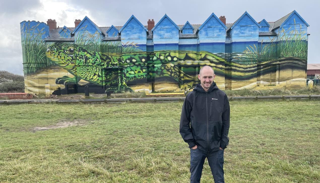 Artist Paul Curtis next to his mural at Toad Hall in Ainsdale in Southport