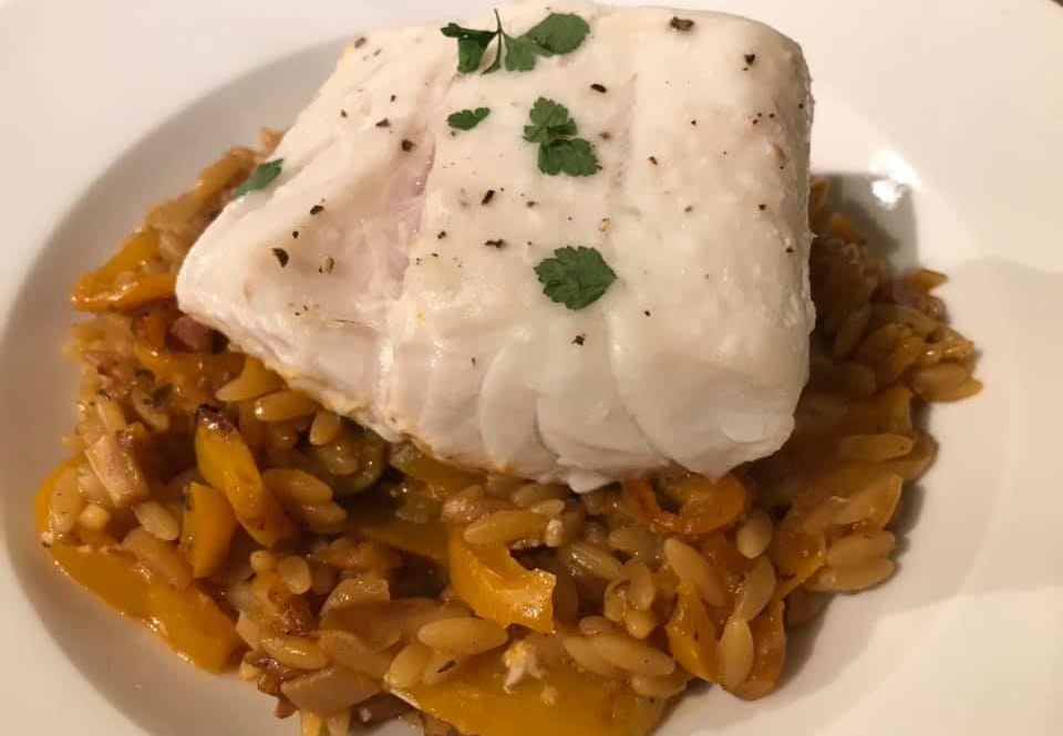 Baked cod with orzo pasta, veg stock, tomato purée, garlic, peppers, onions, olives and oregano. Photo by Andrew Brown Media