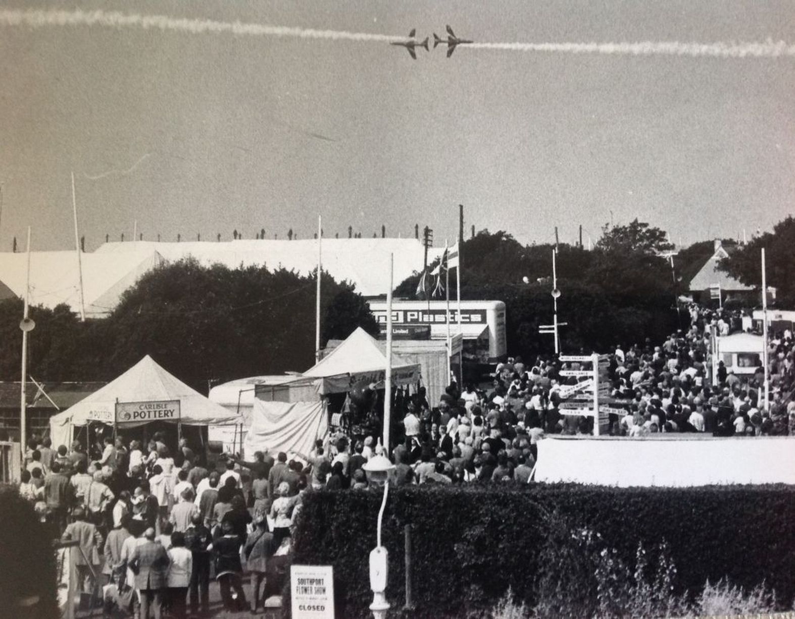 The Red Arrows perform daredevil aerobatics as crowds pack into Victoria Park in Southport for the 1980 Southport Flower Show