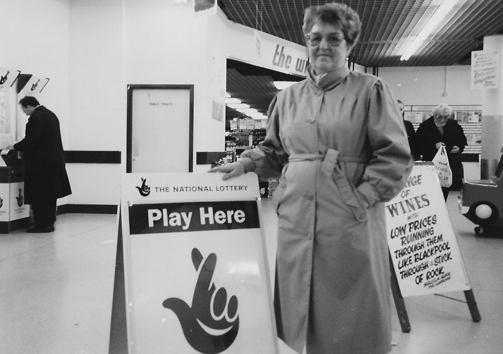 Southport in November 1994. A lady promotes the National Lottery in the former supermarket on Tulketh Street in Southport. The store changed from Mainstop to Morrisons. A sign in the background says 'range of wines with low prices running through them like Blackpool through a stick of rock'