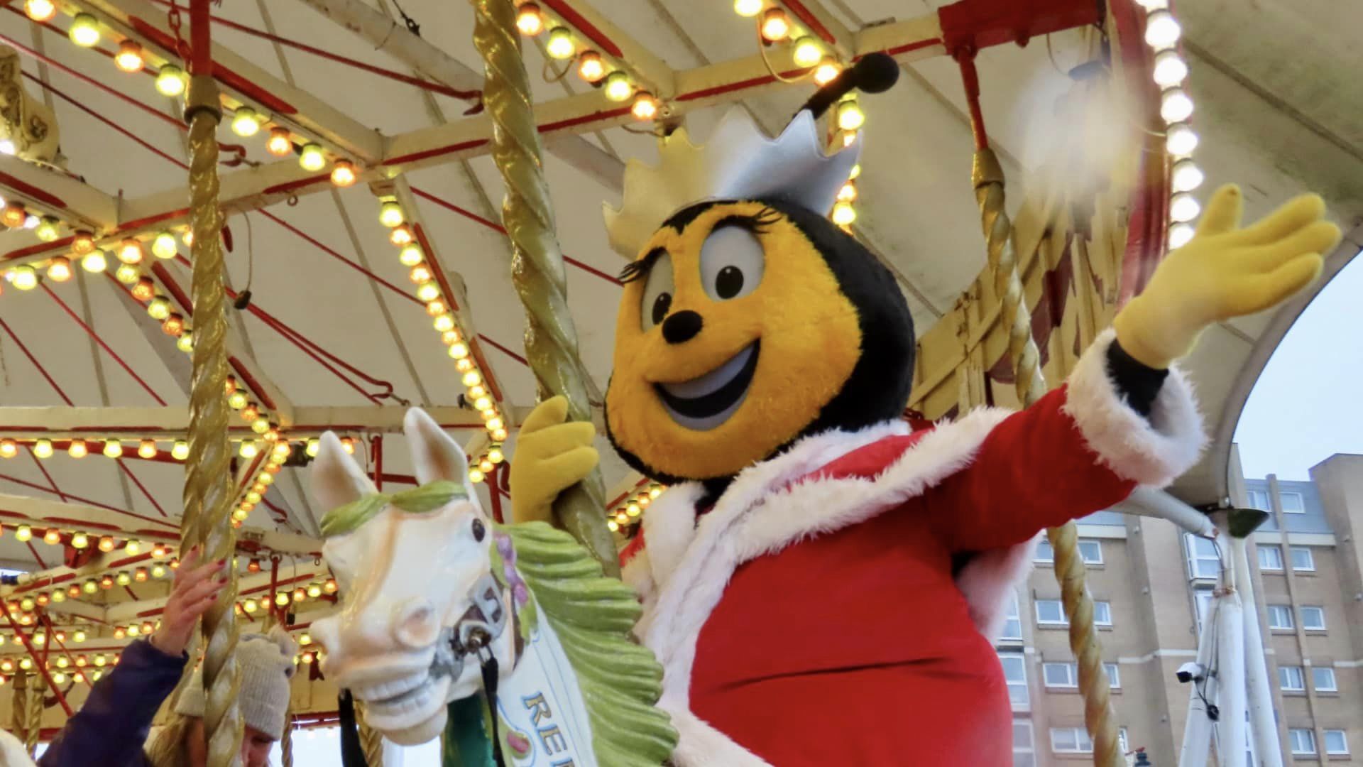Queenie the Bee, the Queenscourt Hospice mascot, enjoys a ride on Silcock's Carousel. Photo by Andrew Brown Media