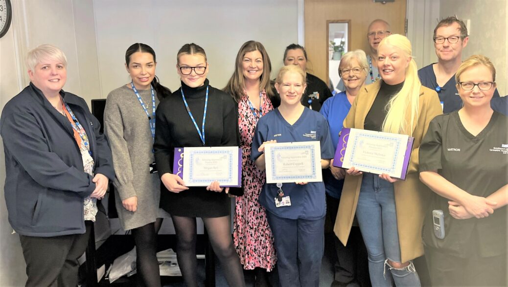Megan Bell and Victoria Webster, third from left and third from right, with their apprenticeship awards supported by colleagues