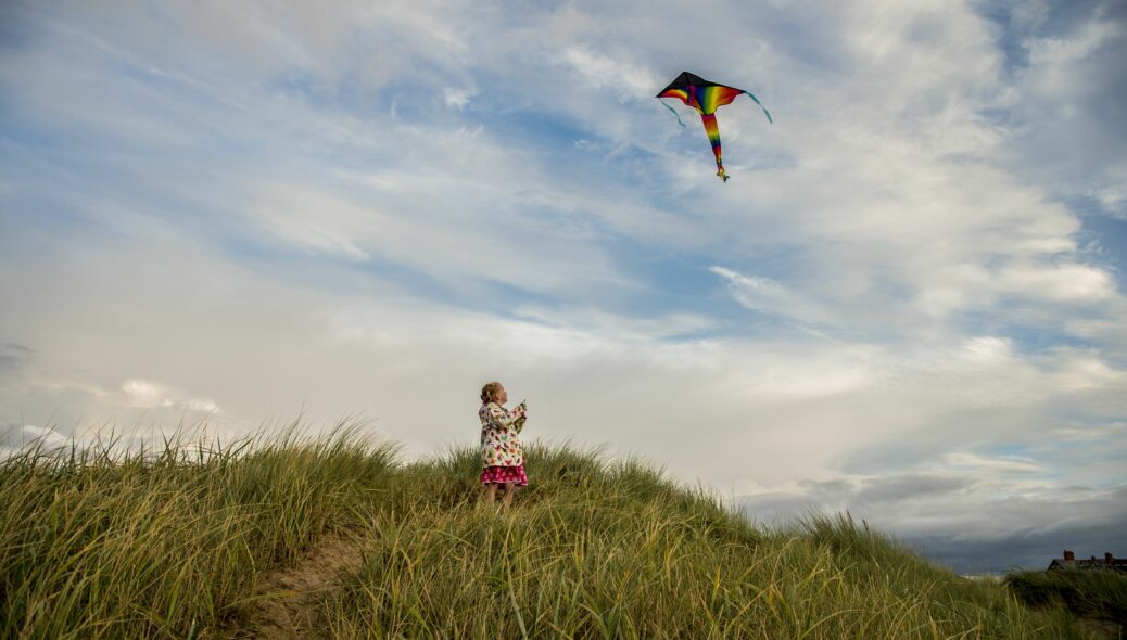 Girl flying kite on the beach. Photo by Visit Southport