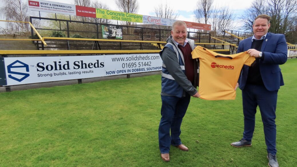 Solid Sheds owner Andy Hayes and Steven Brown from Southport FC next to the new Solid Sheds advertising board at Southport Football Club. Photo by Andrew Brown Media