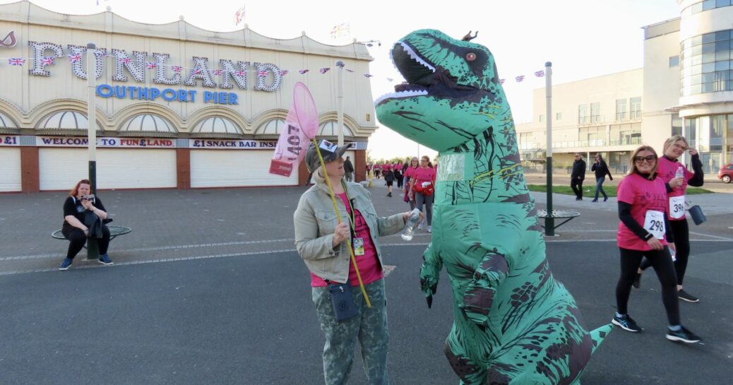 Joanne Caddy and Amanda Bradley were inspired by Jurassic Park to raise funds for Queenscourt Hospice by walking 10 kilometres through the streets of Southport - dressed as an 8ft tall Tyrannosaurus Rex dinosaur and a Jurassic Park Ranger! Photo by Andrew Brown of Stand Up For Southport