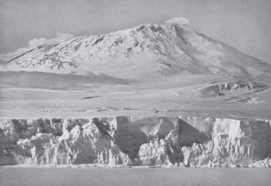 Mount Erebus with ice ramparts in foreground. (The Great White South, opp. p.60, image © A. Strathie)