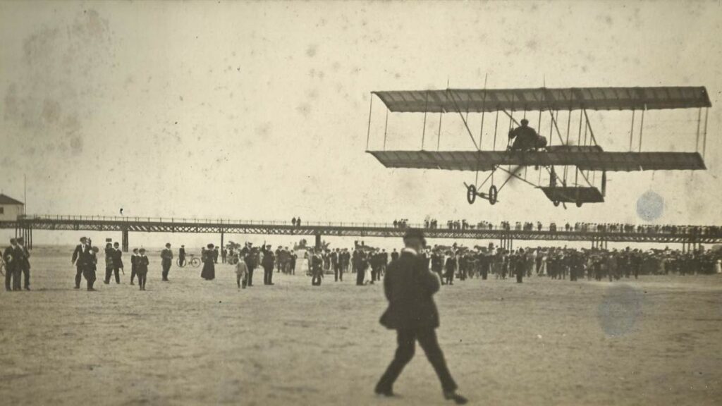 An early aircraft wwows crowds above Southport Beach as spectators line Southport Pier. Photo courtesy of The Atkinson in Southport
