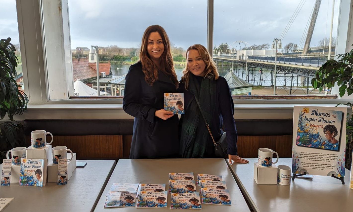 Kayla Woodfine with her book Nurses Have Super Flower Powers and Silcocks Operations Manager Serena Silcock-Prince at Silcocks Pier Family Restaurant