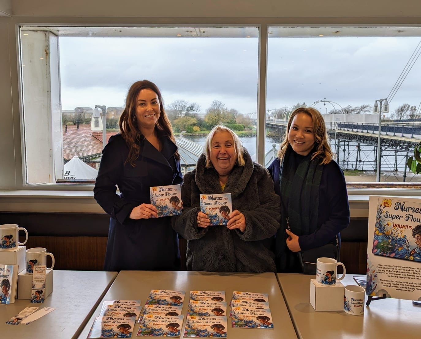 Kayla Woodfine (right) with her book Nurses Have Super Flower Powers and Silcocks Operations Manager Serena Silcock-Prince (left) and reader Leslie Nickeas (centre) at Silcocks Pier Family Restaurant