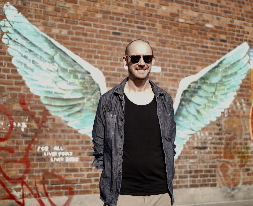 Street artist Paul Curtis next to his work 'For All Liverpool's Liver Birds', (aka 'The Wings'). Photo by Laura McCann