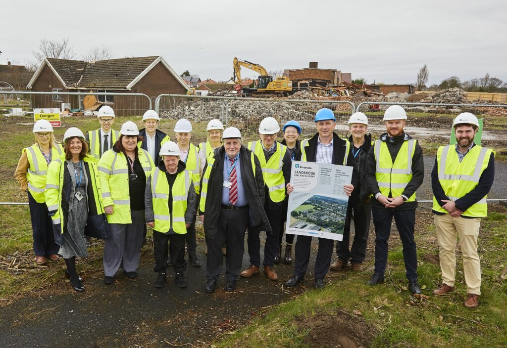Members of Riverside and the Sandbrook co-production group alongside Cllr Paul Cummins (centre) and Sefton Council's Chief Executive Phil Porter (holding a sign about the development).