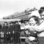 Firefighters from Southport Fire Brigade oversee two schoolboys using a fire engine hose in March 1983