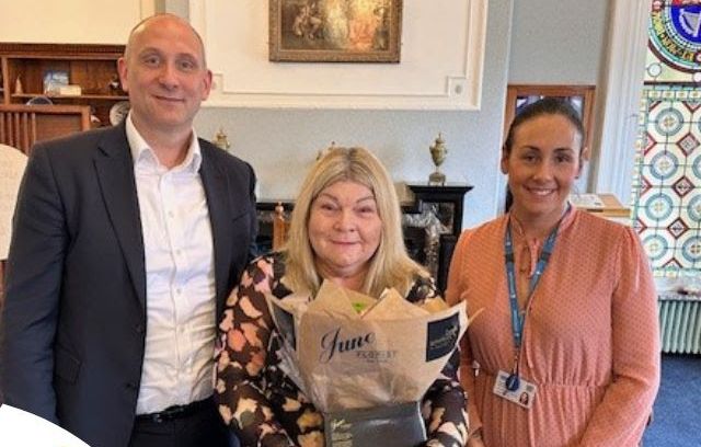 Sefton Chief Executive Phil Porter (Left) presents Gill Glover (middle) with flowers to say 'thank you' for her 50 years of service to the council They are joined by Gill's manager Paula Bradshaw (right)