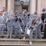 Twelve people have completed a bold escape from the cells at Southport Police Station in the annual Jail and Bail fundraiser for Queenscourt Hospice. Inmates outside the former Southport Magistrates Court (now Access Point) with Sefton Police officers