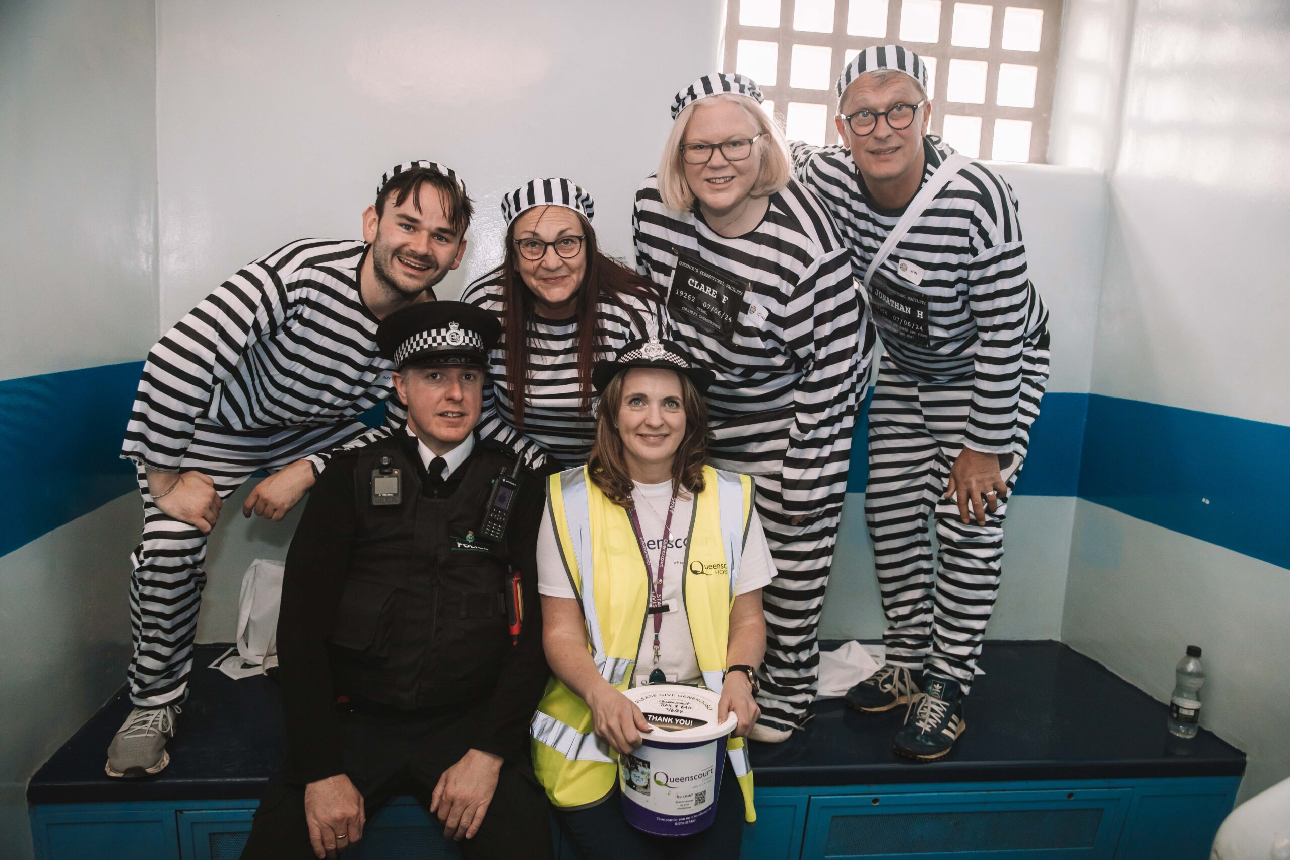 Twelve people have completed a bold escape from the cells at Southport Police Station in the annual Jail and Bail fundraiser for Queenscourt Hospice. Inmates at Southport Police Station with Queenscourt Fundraising Manager Liz Hartley 
