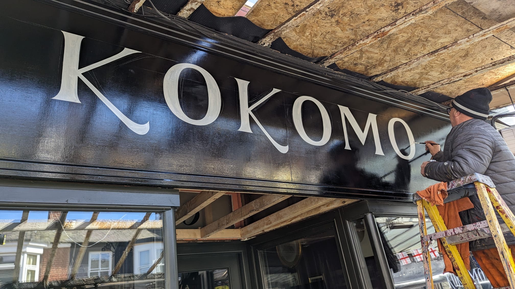 Sign writer Graham Booth works on the new sign at Kokomo Coffee & Wine Bar in Southport