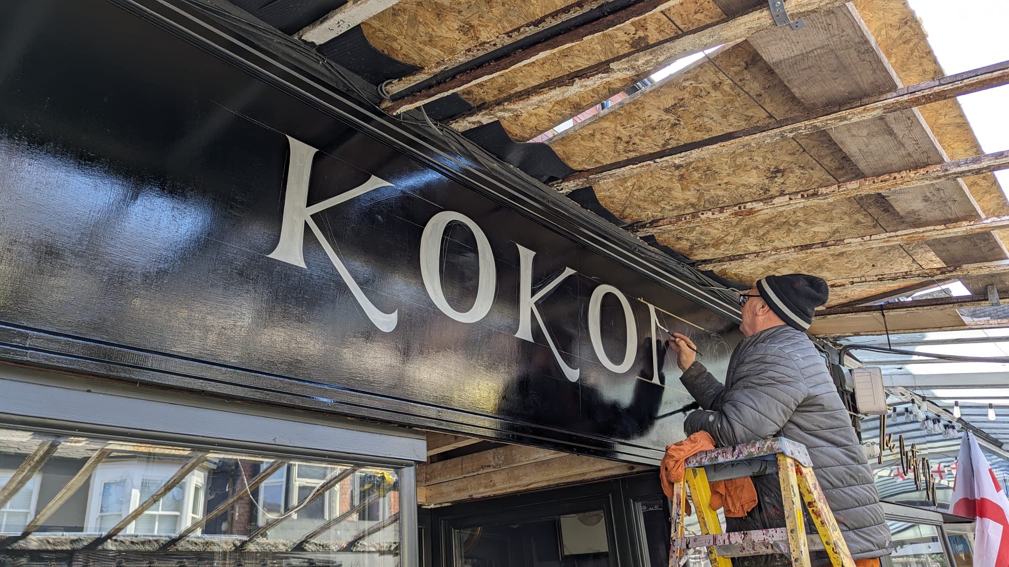 Sign writer Graham Booth works on the new sign at Kokomo Coffee & Wine Bar in Southport