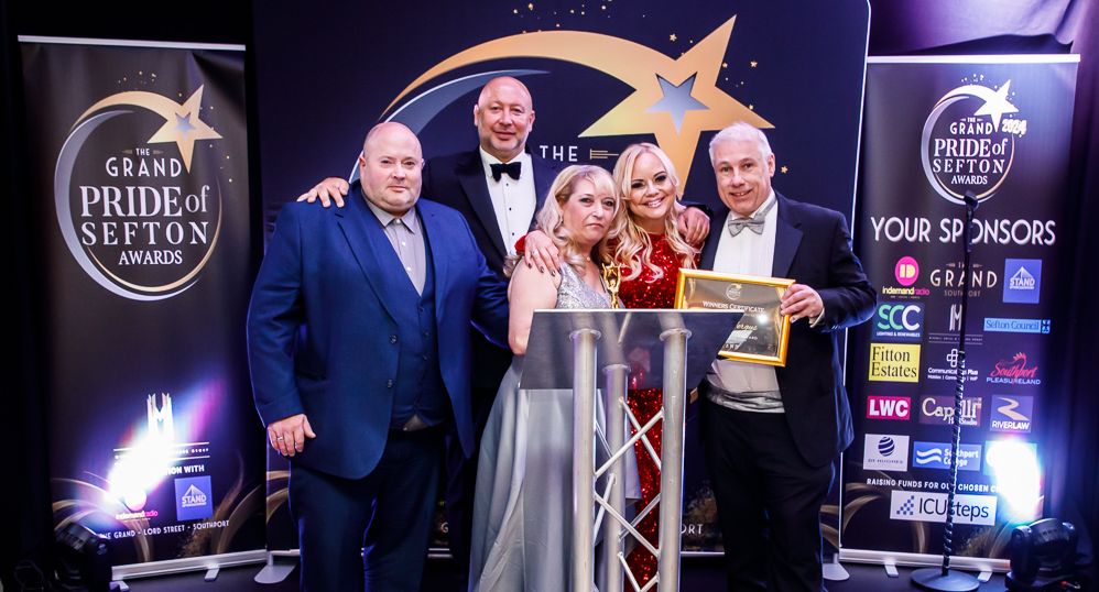 Denise and Stuart Fergus are presented with the Main Award at the 2024 Grand Pride Of Sefton Awards. They are with Mikhail Hotel and Leisure Group Chairman Andrew Mikhail; In demand Radio presenter Claire Simmo; and Stand Up For Southport Diector Andrew Brown. Photo by Kevin Brown Photography