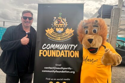 Scott Blundell and Sandy the Lion at the Southport FC Comnmunity Foundation. Photo by Andrew Brown Stand Up For Southport