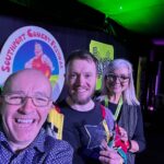 The Southport New Comedian of The Year competition sponsored by Dragon Soop. Winner Rich McCulloch (centre) with festival director Brendan Riley (left) and Isabelle Kent (Dragon Soop, right)