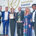 Making Energy Greener is celebrating earning national recognition in two categories at the Energy Efficiency Awards 2025 in Birmingham. They are pictured on stage with Soanday Ballet star Tony Hadley (left) Photo by Jason Mitchell Photography
