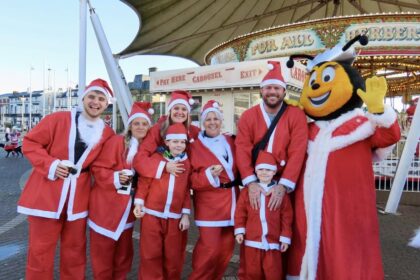 Supporters gather for the Southport Santa Sprint for Queenscourt Hospice outside Silcock's Funland and Carousel. Photo by Andrew Brown Stand Up For Souhtport