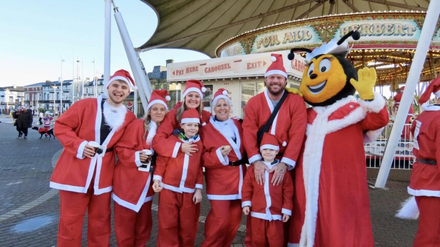 Supporters gather for the Southport Santa Sprint for Queenscourt Hospice outside Silcock's Funland and Carousel. Photo by Andrew Brown Stand Up For Souhtport