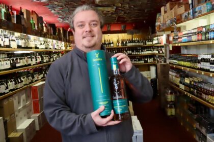 Portland Wine Cellars in Southport. Owner Phil Barber with a bottle of 16 year old Glenfiddich. Photo by Andrew Brown Stand Up For Southport