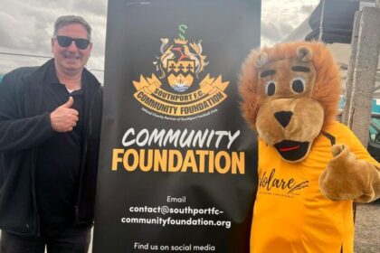 Scott Blundell and Sandy the Lion at the Southport FC Comnmunity Foundation. Photo by Andrew Brown Stand Up For Southport