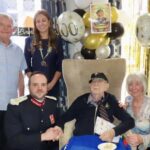 Former Royal Marine Stan Woolley has celebrated his 100th birthday at Ivy Gate Lodge Care Home in Southport. Guests included Merseyside Lord Lieutenant Peter Oliver OBE and Southport Royal British Legion President Serena Silcock-Prince, pictured with Stan's niece Jackie Ryan and her husband George. Photo by Andrew Brown Stand Up For Southport
