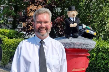 Michael Rushton with the knitted postbox topper from Southport Hookers outside the funeral home