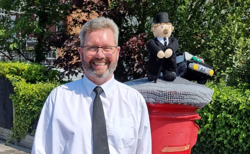 Michael Rushton with the knitted postbox topper from Southport Hookers outside the funeral home