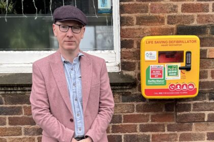 Patrick Hurley MP next to a defibrillator