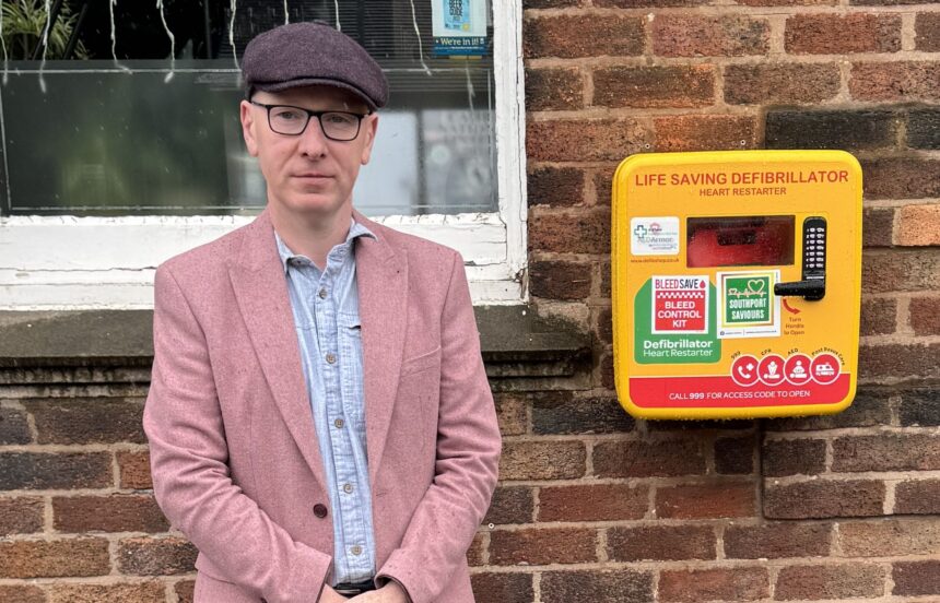 Patrick Hurley MP next to a defibrillator